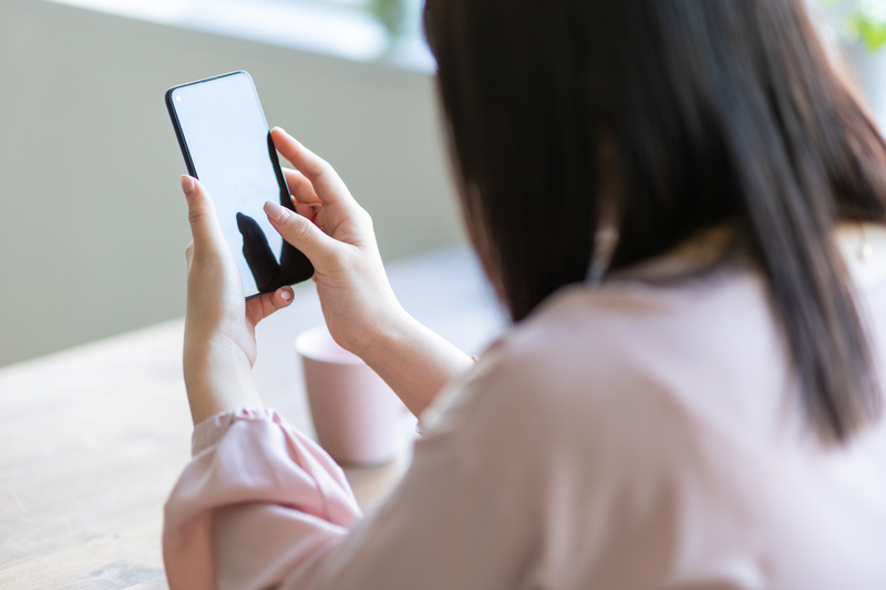 スマホを見る女性の後ろ姿